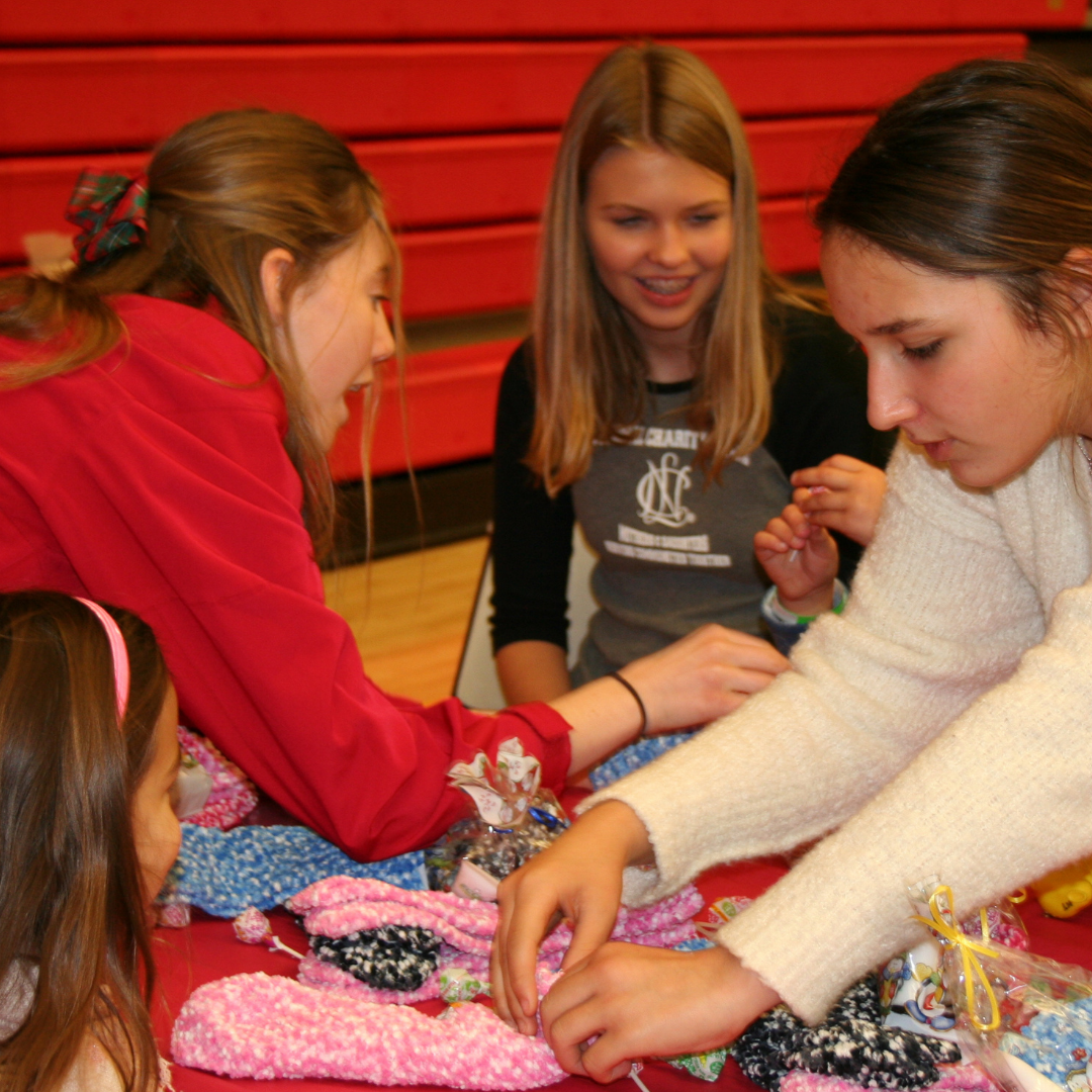 Four teenage girls making crafts around a table at a Holiday Craft Party a couple of years ago.