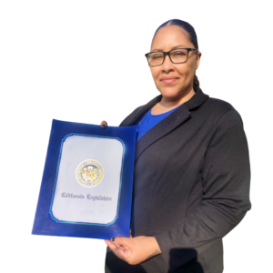 Kristina, Women's Empowerment graduate, holding a certificate of graduation, in front of a white background