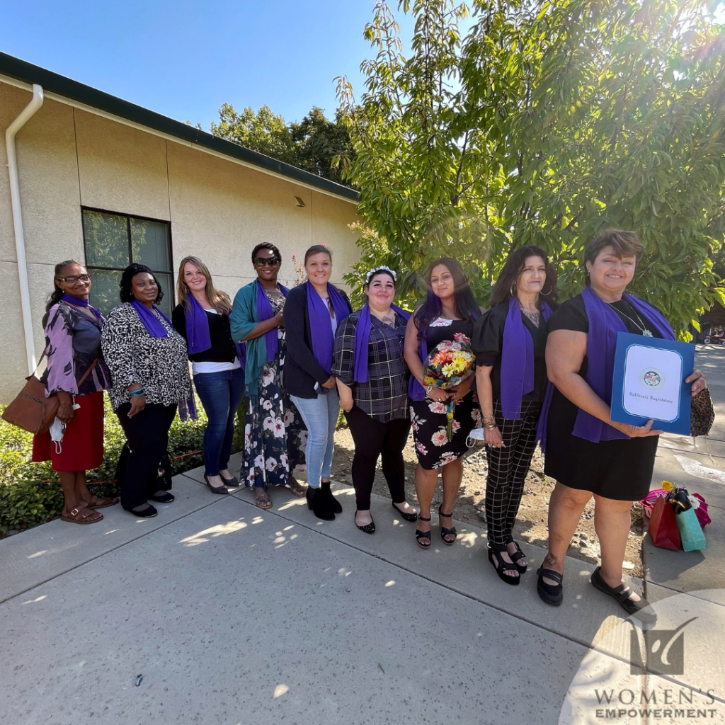 A group 9 of the Session 84 graduates, holding up their diplomas on graduation day, in the backyard of Women's Empowerment.