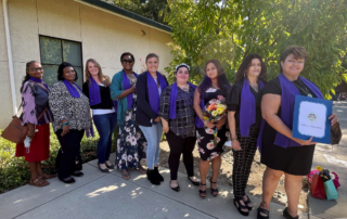 A group 9 of the Session 84 graduates, holding up their diplomas on graduation day, in the backyard of Women's Empowerment.